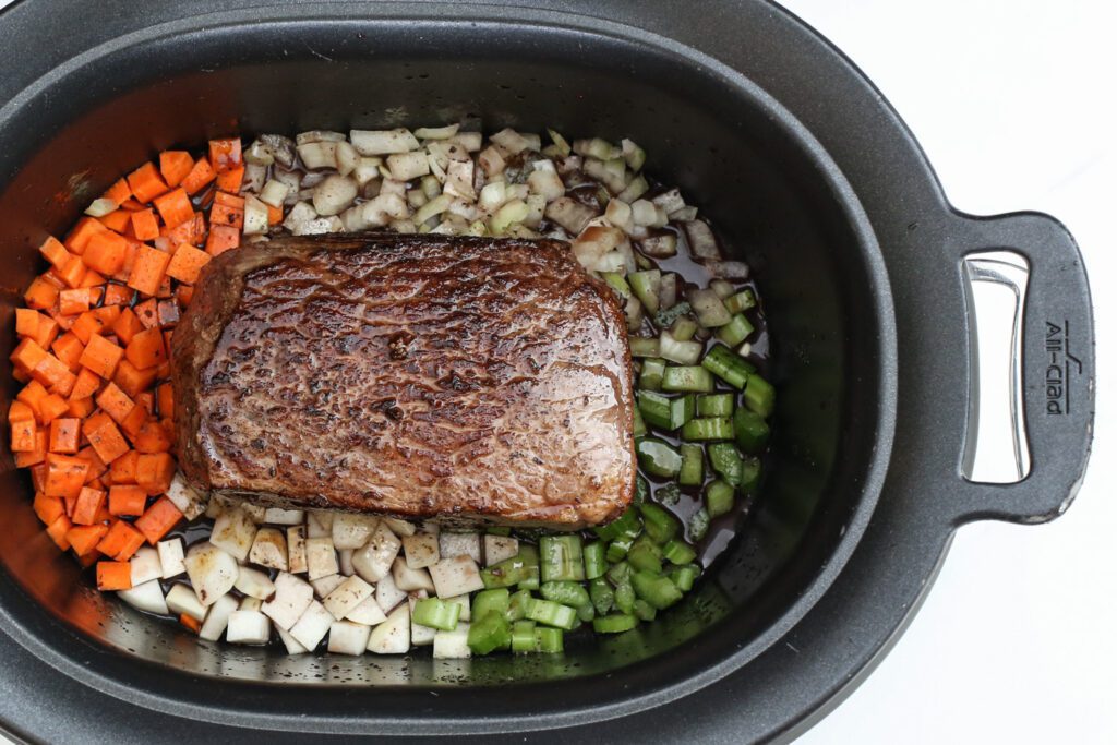 pot roast seared and ready to cook in the slow cooker with vegtetables