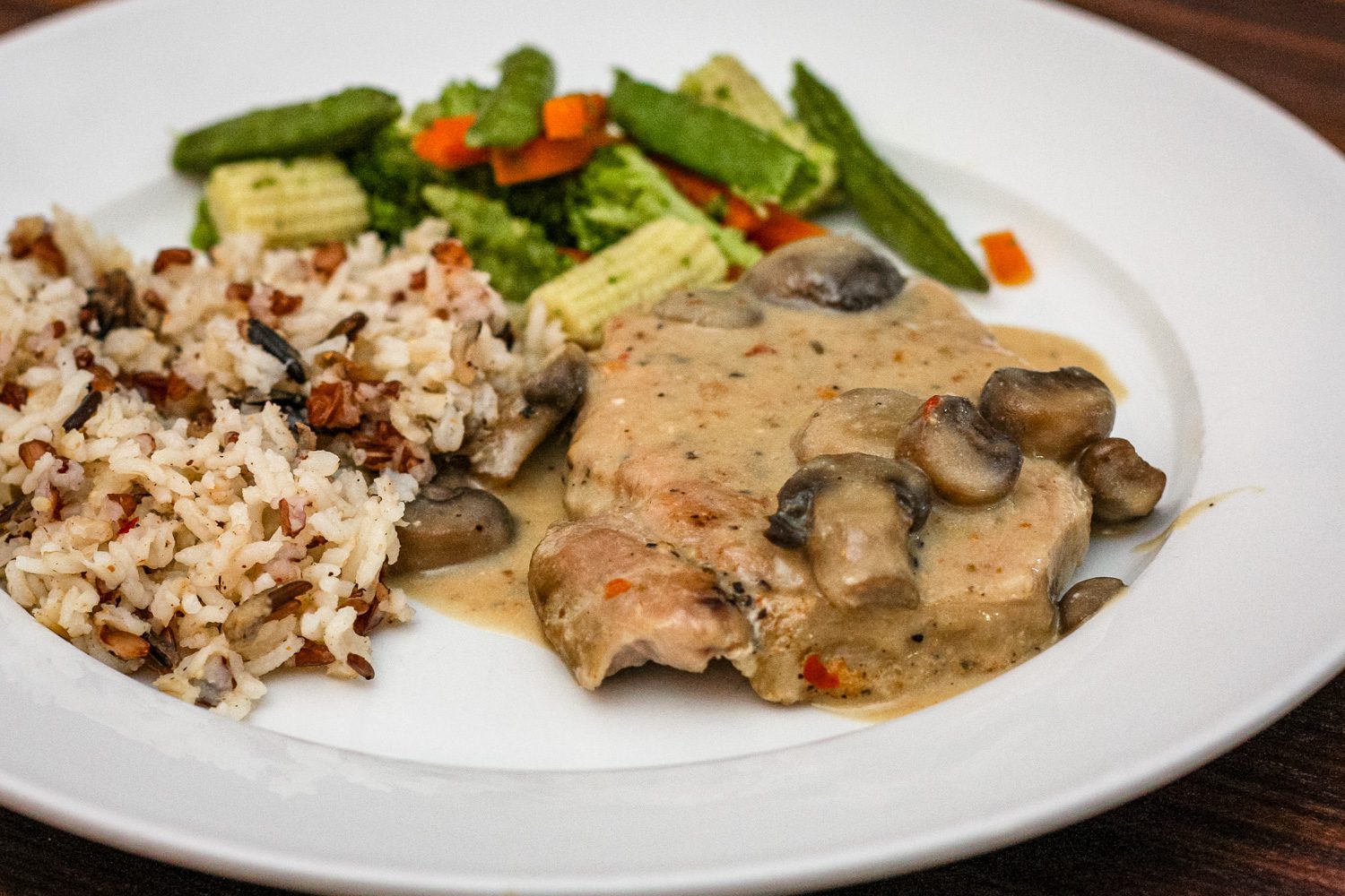 slow cooker pork chops on a plate with rice and vegetables