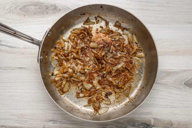 Smothered pork chops prep: onions are browned in the skillet with butter.