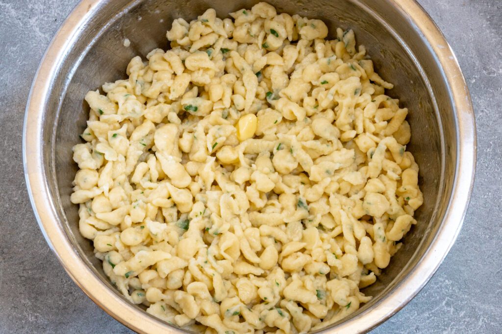 A bowl of freshly made spaetzle with herbs and butter