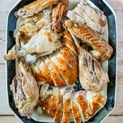 A carved spatchcocked turkey on a large platter.