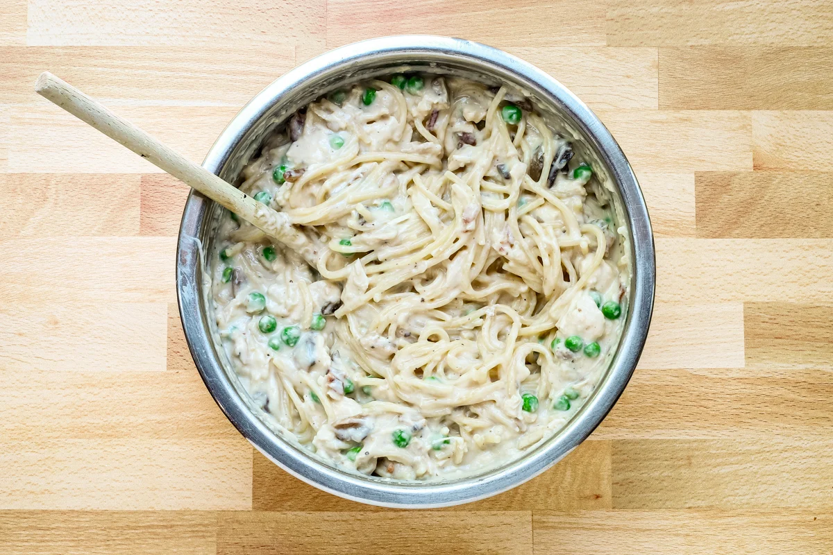 The spaghetti is added to the sauce mixture.