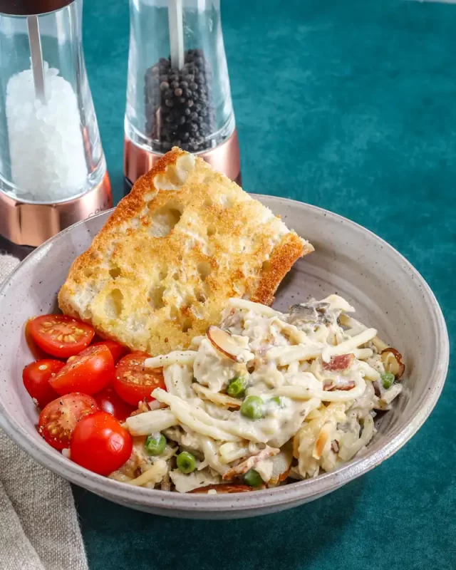 Fettuccine Alfredo with cherry tomatoes and garlic bread.