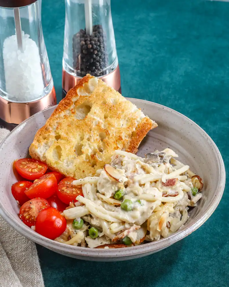 Fettuccine Alfredo with cherry tomatoes and garlic bread.