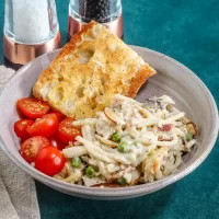 Creamy pasta with peas and cherry tomatoes, served with garlic bread.