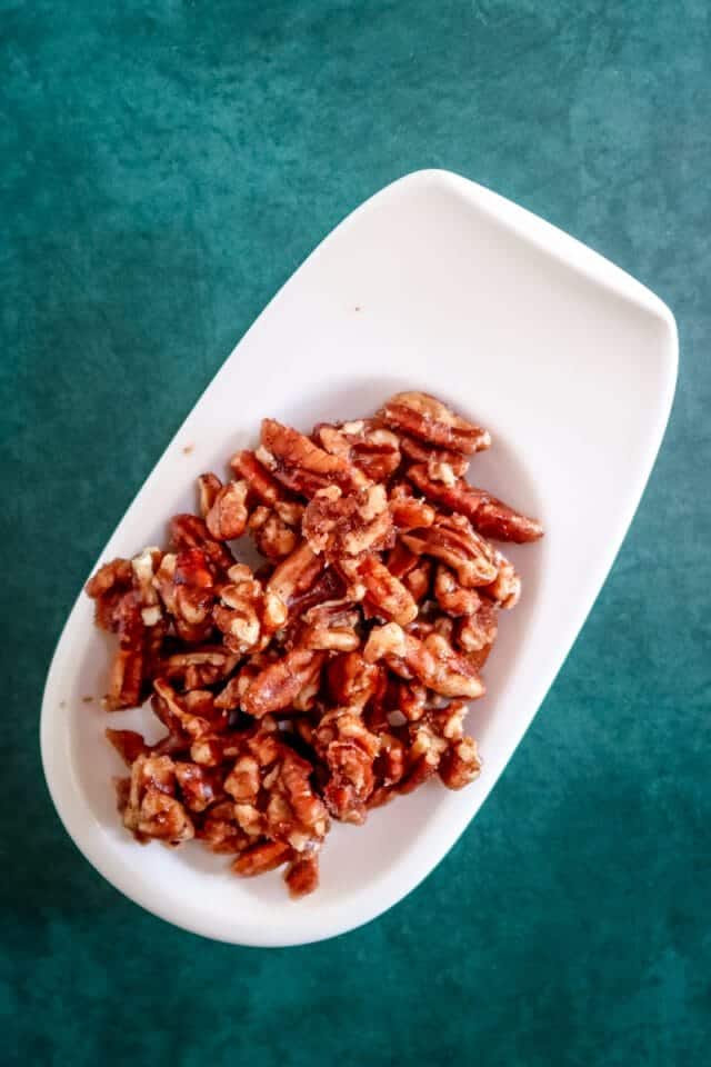 Crumbled cooked bacon on white serving dish.