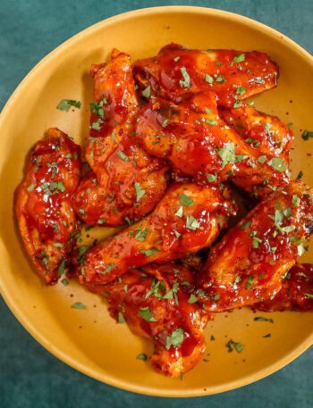 air fryer chicken wings in a bowl with korean style sauce