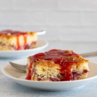 strawberry crumb cake with strawberries and pecans in the middle and strawberry sauce on top