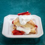 strawberry shortcake on a split cream biscuit with freshly whipped cream