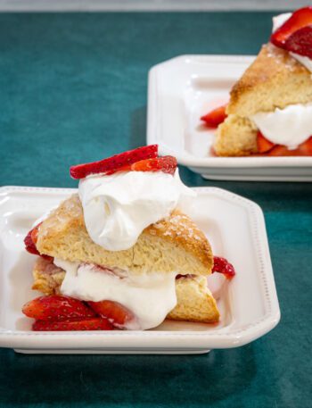 strawberry shortcakes on a plate: cream biscuits with strawberries and whipped cream