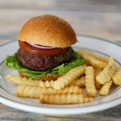bacon and cheese stuffed burgers on a plate with fries