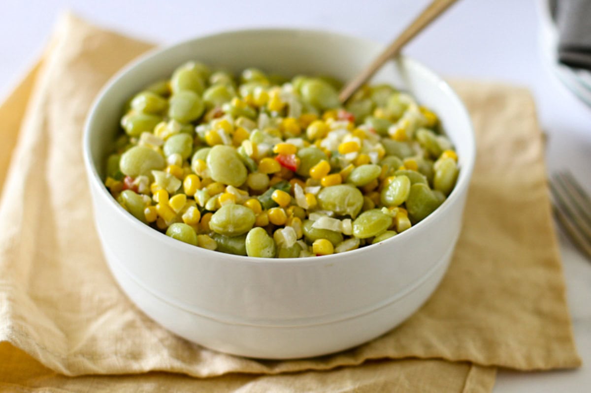 A serving bowl of succotash with lima beans and corn.