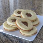 filled sugar cookies with cut-outs, on a plate