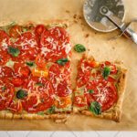 a summer tomato tart with a slice cut out of it