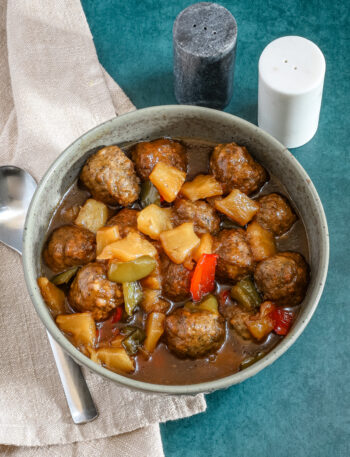 Slow cooker sweet and sour meatballs with bell pepper and pineapple chunks.