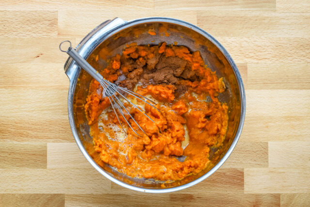 Mashing the sweet potatoes and combining them with the egg, spices, and brown sugar.