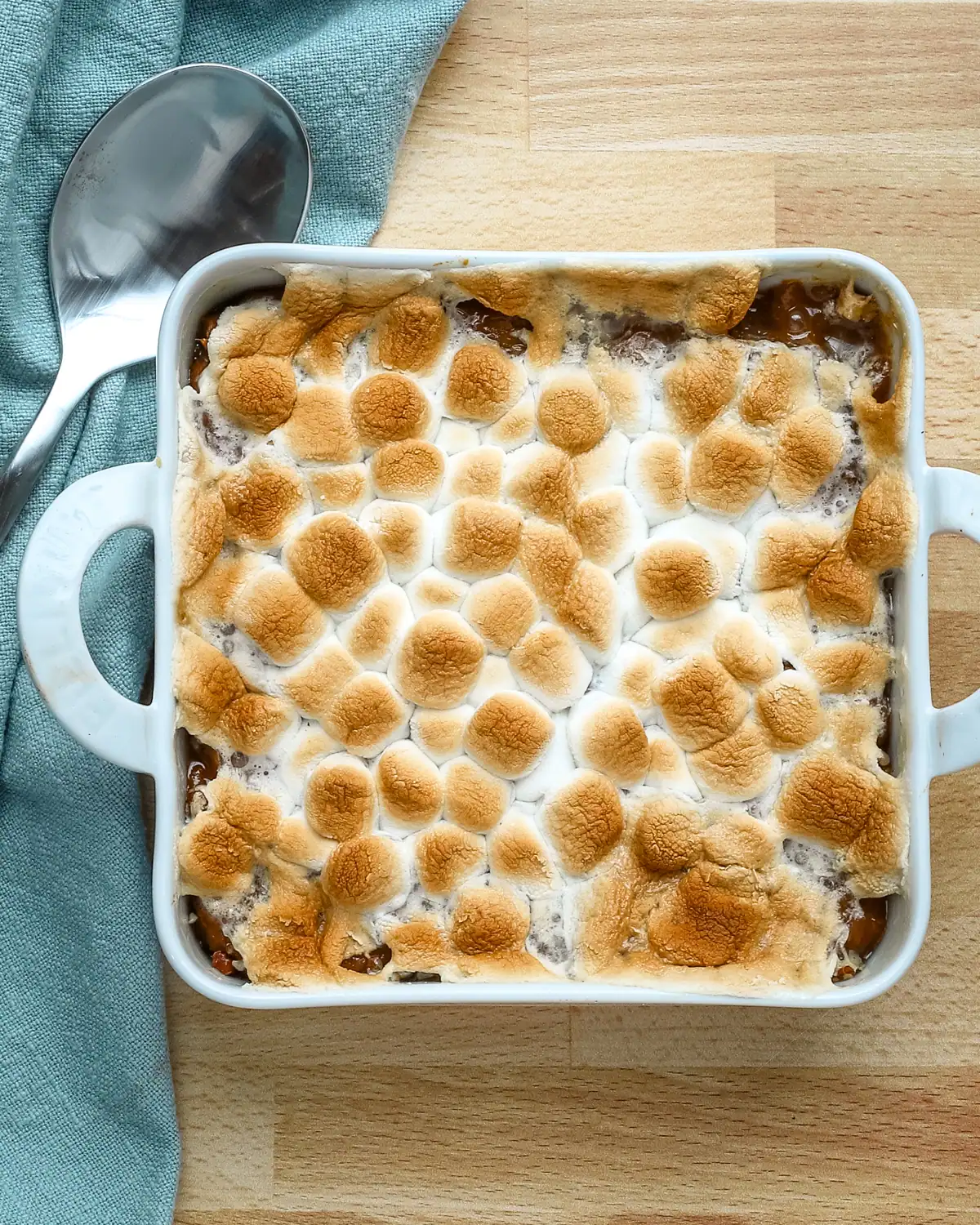 Golden toasted marshmallows on top of a baked dessert.