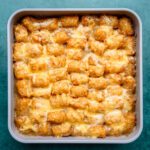 a baking pan of tater tot casserole with cheese topping