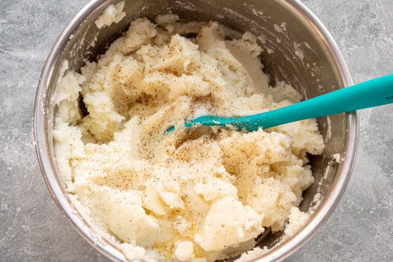 Mashing the potatoes in a large bowl.