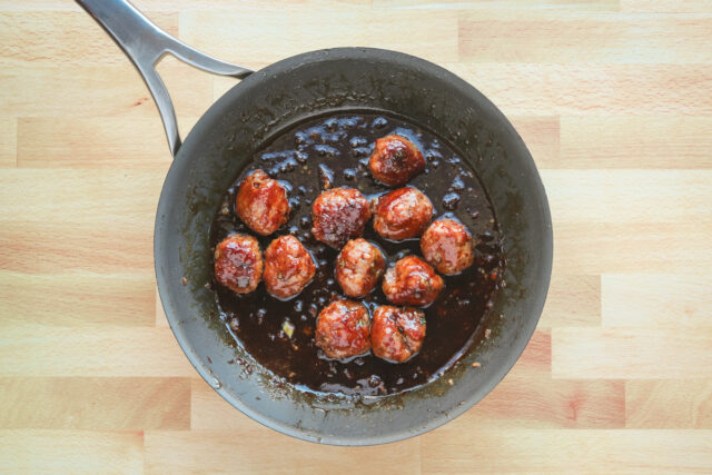 Teriyaki meatballs in the skillet with sauce.