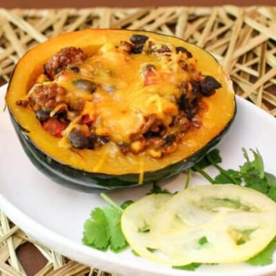 tex mex stuffed acorn squash with ground beef and black beans on a plate