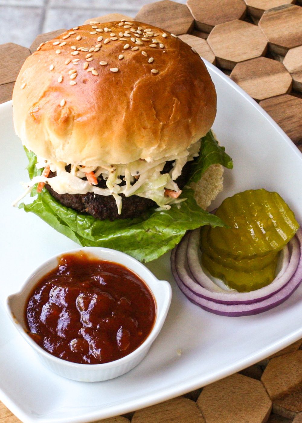 texas burger on a plate with coleslaw topping and bbq sauce
