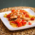 a plate with creole style pork chops and tomatoes