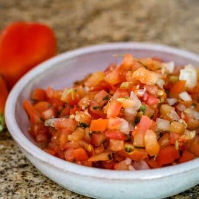 a small bowl of tomato salsa with chile peppers