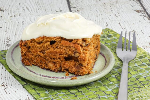 A slice of tomato soup cake shown with cream cheese icing.