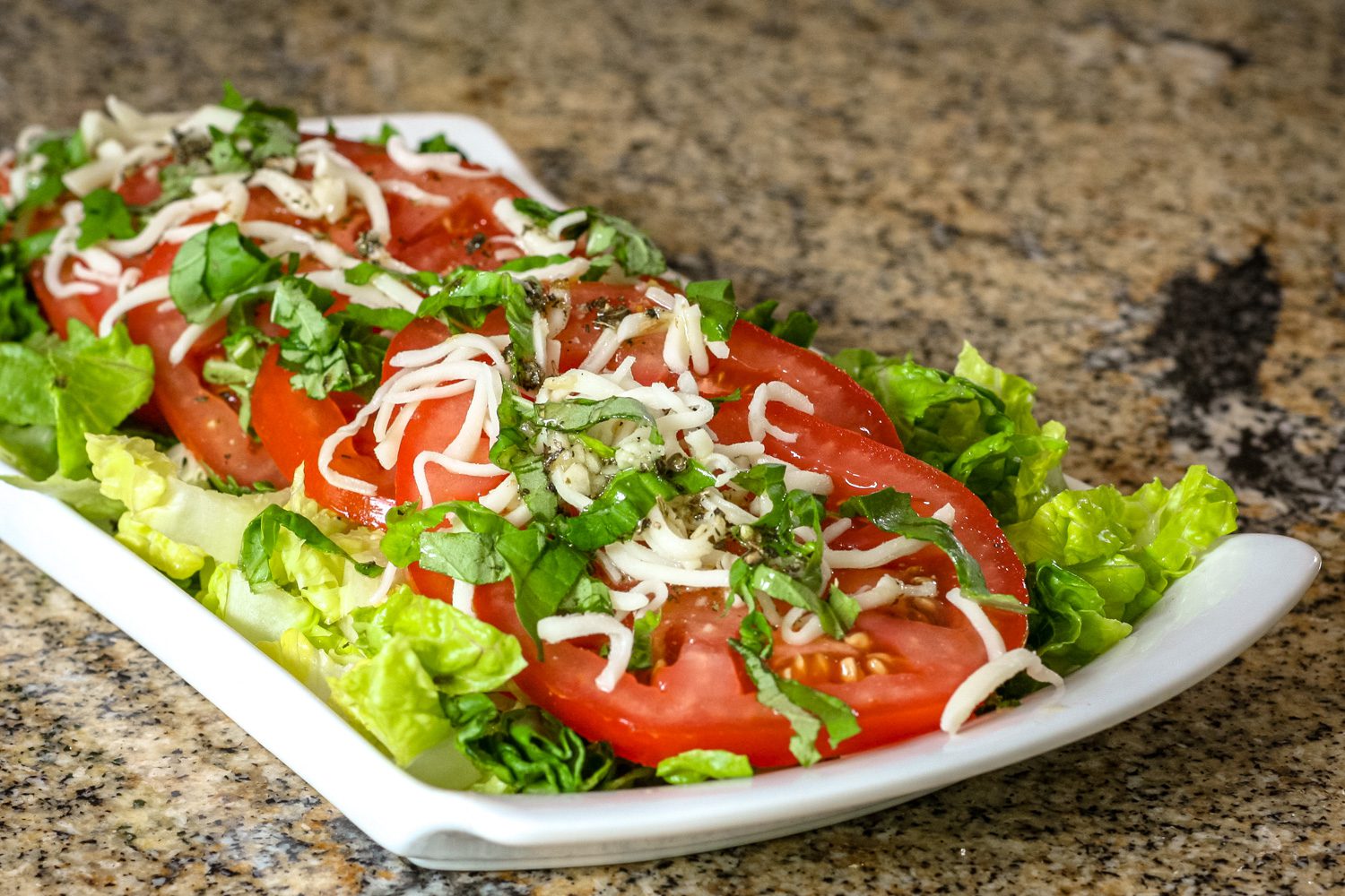 A small serving platter with tomatoes with red wine vinaigrette