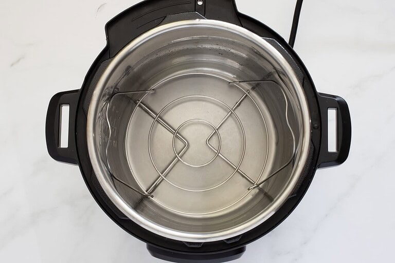 Empty stainless steel inner pot of an Instant Pot or pressure cooker.