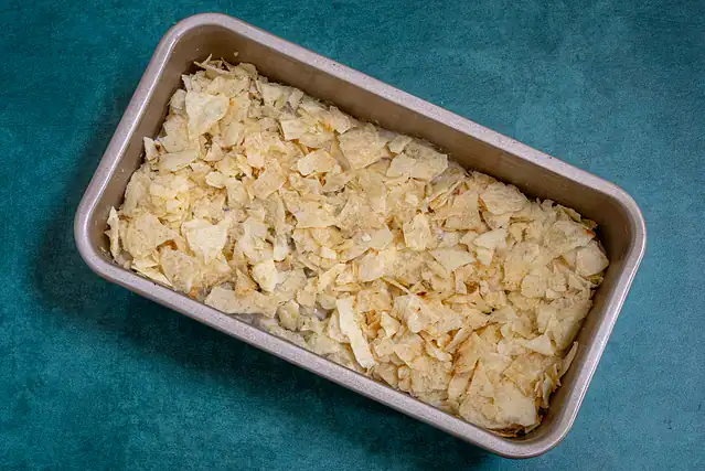 Tuna casserole in a loaf pan with potato chip topping.