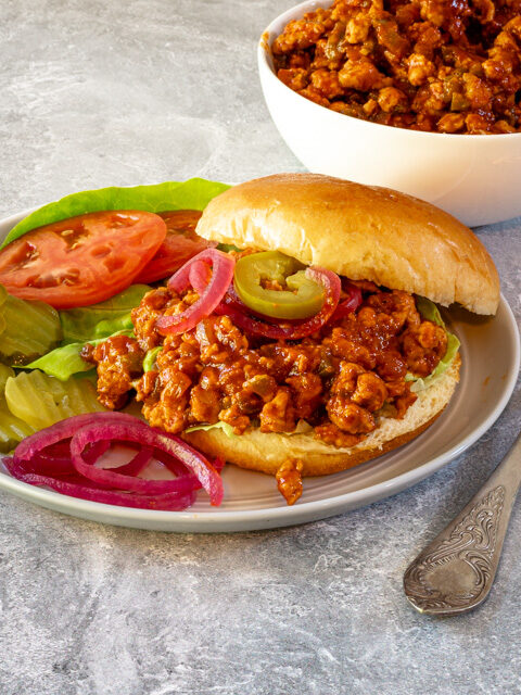 plate with sloppy joe sandwich and vegetables on the side