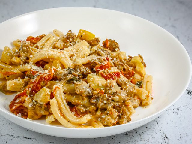 pasta with sausage and sun-dried tomatoes in a bowl