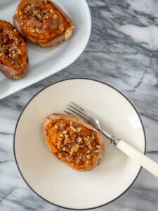 a stuffed sweet potato with brown sugar and pecan topping