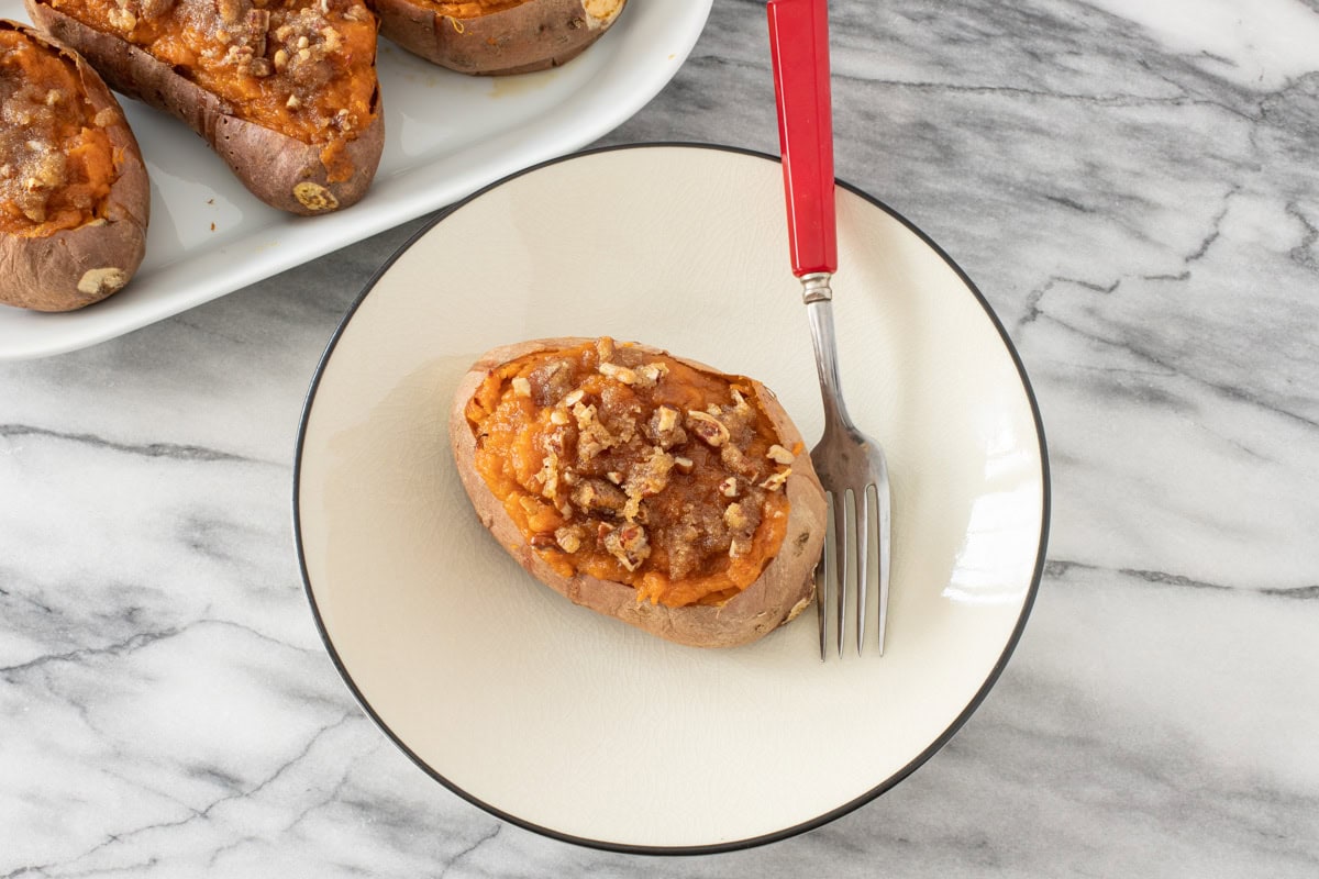 A twice baked sweet potato on a plate with a streusel topping.