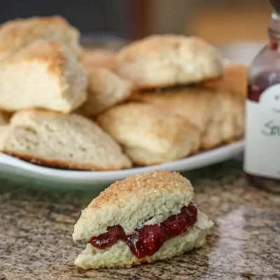 Fluffy scone with cherry jam and whipped cream.