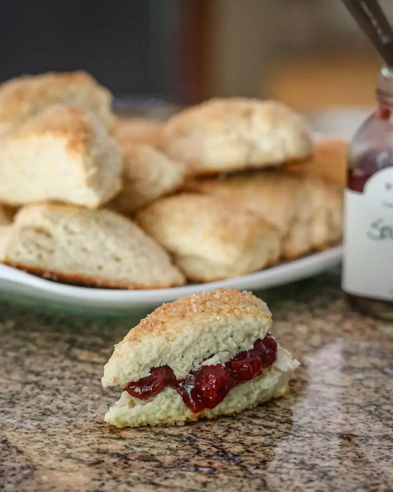 Fluffy scone with cherry jam and whipped cream.
