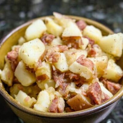 A serving bowl with warm, Cajun flavored potato salad