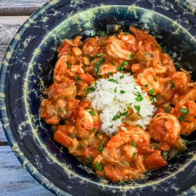 Creamy shrimp and vegetable stew with rice in a rustic bowl.