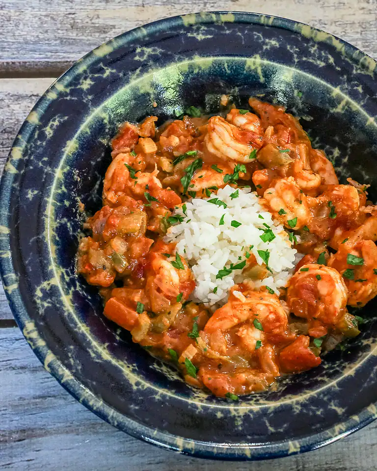 Creamy shrimp and vegetable stew with rice in a rustic bowl.