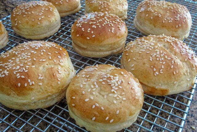 hamburger buns with sesame seeds on a cooling rack