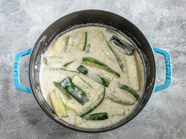 Finishing the zucchini dish with sour cream sauce.