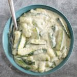 A serving bowl with zucchini cooked in a sour cream sauce.