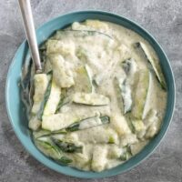 A serving bowl with zucchini cooked in a sour cream sauce.